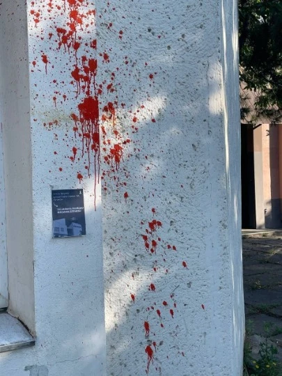 Акція українських активістів руху Жовта стрічка: листівка з написом та штучна кров на стіні