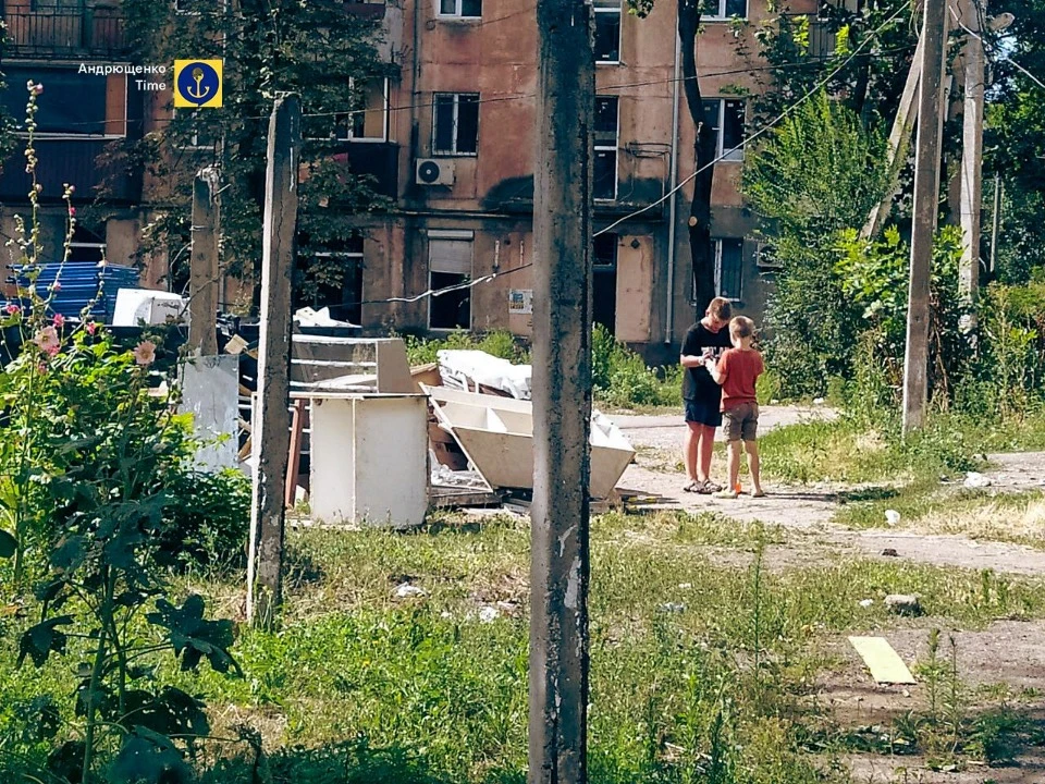 Діти, що граються на фоні зруйнованих будинків в Маріуполі