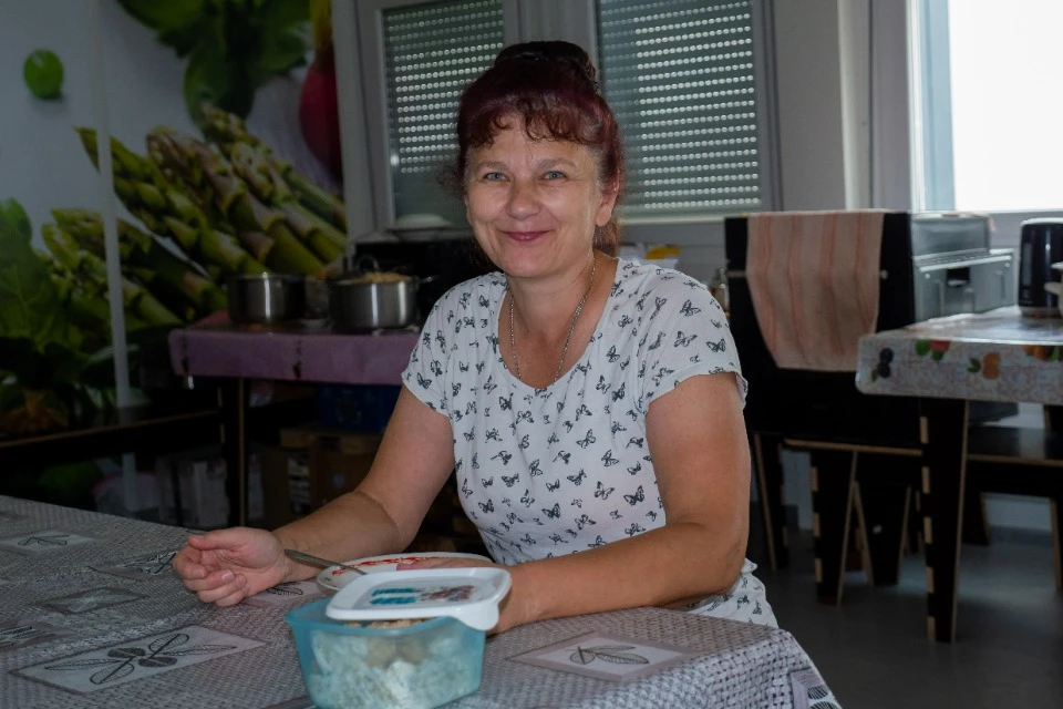 Переселенка за обедом в модульном городке Бородянки