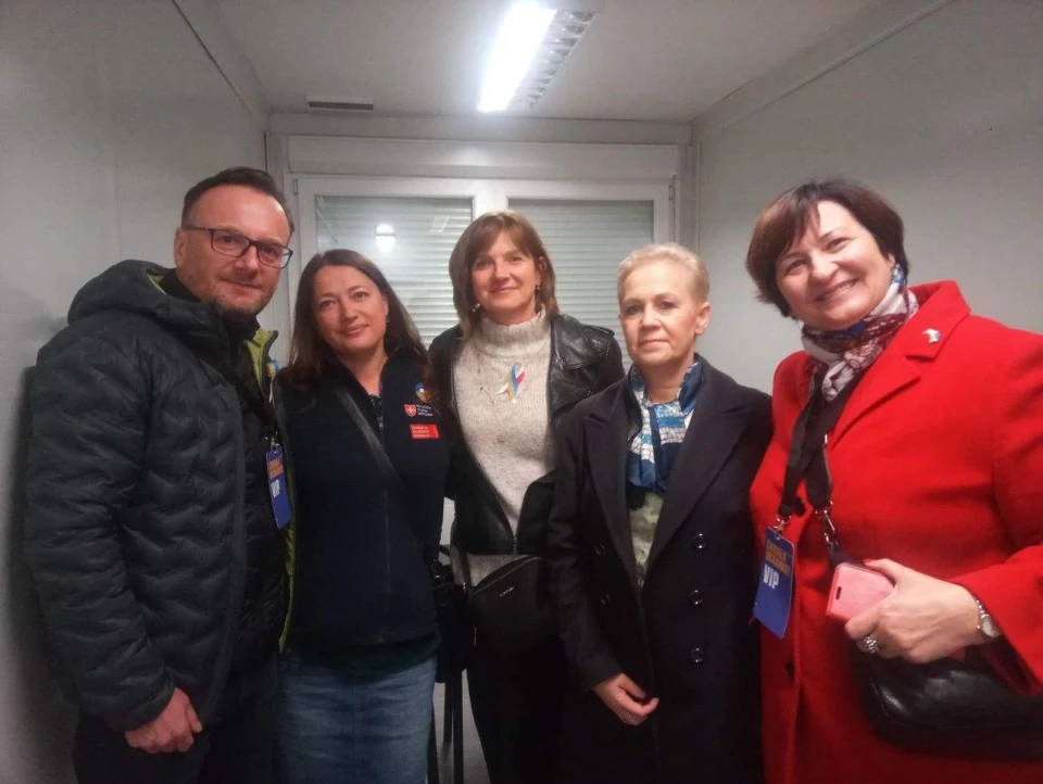 Жінка разом з іноземними громадськими діячами