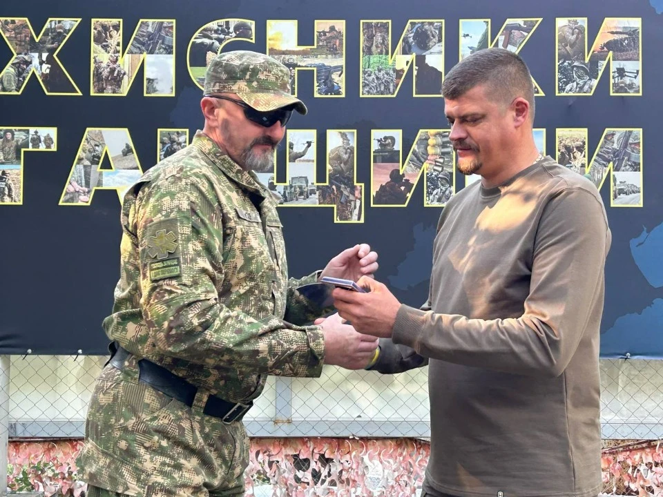 Артем Лисогор вручає нагороду військовому з Луганщини
