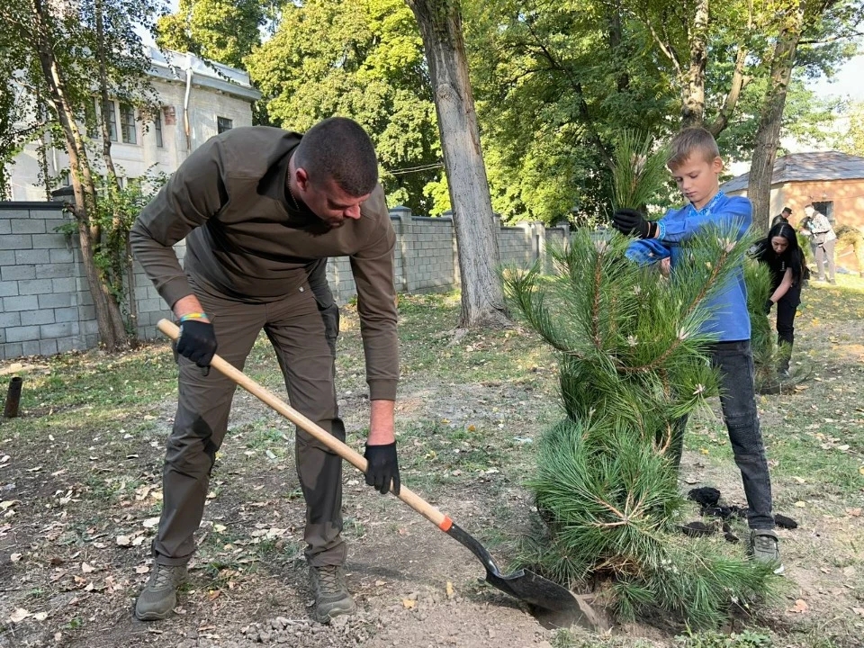 Артем Лисогор висаджує сосну разом з сином Ярославом